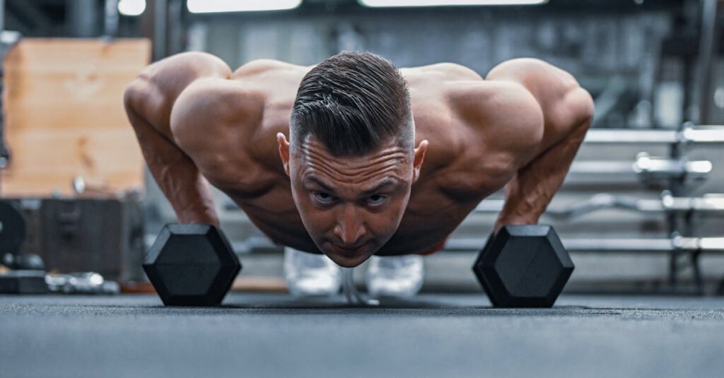 Fit man doing push-ups on hex dumbbells in a modern gym setting.